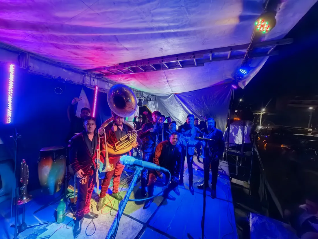Banda sinaloense banda sinaloense Músicos de banda sinaloense tocando metales bajo iluminación azul y violeta